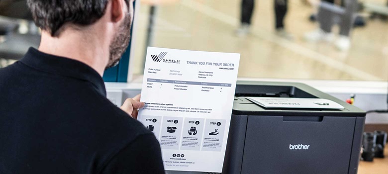 Moški drži povratnico, tiskalnik, okno v centru za obdelavo naročil