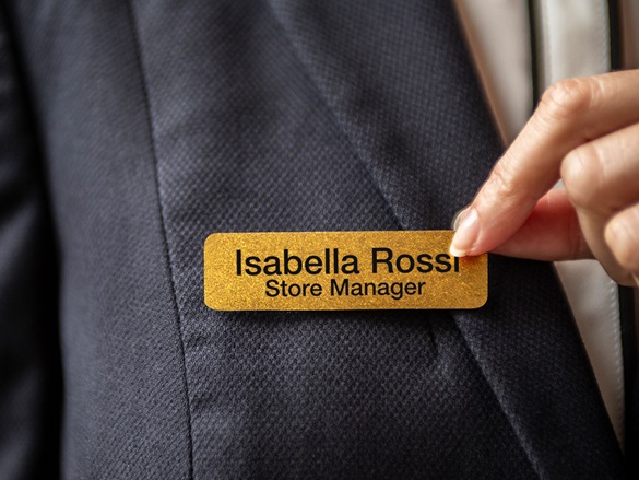 Brother black on premium glitter gold tape attached to clip-on badge to identify store manager