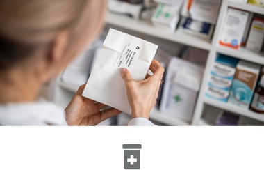Farmacevtka v lekarni lepi nalepko na zdravila